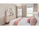Bright bedroom featuring a stylish dresser, decorative mirror, and large windows for natural light at 1302 Nestled Valley Rd, Minneola, FL 34715