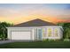 Charming single-story home with a two-car garage and well-manicured lawn at sunset at 1302 Nestled Valley Rd, Minneola, FL 34715