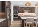 Stylish kitchen with stainless steel appliances, dark wood cabinets, and an island with comfortable seating at 1302 Nestled Valley Rd, Minneola, FL 34715