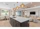 Open kitchen featuring a large island with seating, sink, and stylish pendant lighting above at 1302 Nestled Valley Rd, Minneola, FL 34715
