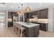 Spacious kitchen featuring an island with seating, stainless appliances, and stylish woven pendant lighting at 1302 Nestled Valley Rd, Minneola, FL 34715