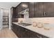Modern kitchen features stainless steel appliances, dark wood cabinets, and a white countertop at 1302 Nestled Valley Rd, Minneola, FL 34715