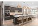 A spacious kitchen features an island with seating, stainless appliances, and stylish woven pendant lighting at 1302 Nestled Valley Rd, Minneola, FL 34715
