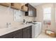 Bright laundry room featuring a sink, modern washer and dryer, and ample storage cabinets at 1302 Nestled Valley Rd, Minneola, FL 34715