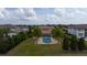 An aerial view of the backyard of a luxury home, featuring a blue pool, spa, and manicured lawn at 13125 Casabella Dr, Windermere, FL 34786