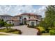 Beautiful two-story home featuring a tile roof, arched windows, and lush, well-maintained landscaping at 13125 Casabella Dr, Windermere, FL 34786