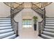 Bright foyer with a grand double staircase and a view to the pool through the doorway at 13125 Casabella Dr, Windermere, FL 34786