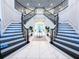 Bright foyer with a grand double staircase featuring white risers, dark treads, and ornate iron railings at 13125 Casabella Dr, Windermere, FL 34786