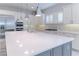 Bright kitchen featuring an island with white countertop, stainless steel appliances, and modern pendant lighting at 13125 Casabella Dr, Windermere, FL 34786