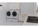 Bright laundry room with modern washer, dryer, and sink, plus white cabinetry and marble tile flooring at 13125 Casabella Dr, Windermere, FL 34786
