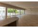 Expansive living room features tile floors, a wet bar, and sliding glass doors opening to a pool and lush landscaping at 13125 Casabella Dr, Windermere, FL 34786