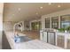 This outdoor kitchen features stainless appliances, a granite countertop, and a stainless sink in a covered entertainment area at 13125 Casabella Dr, Windermere, FL 34786