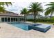 Backyard featuring a pool with an integrated spa, palm trees, and the main house at 13125 Casabella Dr, Windermere, FL 34786