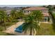 An aerial view of the backyard of a luxury home, featuring a blue pool, spa, and manicured lawn at 13125 Casabella Dr, Windermere, FL 34786