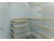 Spacious walk-in closet with custom shelving, rods, and storage bins for organization at 13125 Casabella Dr, Windermere, FL 34786