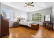 Bright bedroom featuring a vaulted ceiling, hardwood floors, and large windows offering a serene view at 13640 Dornoch Dr, Orlando, FL 32828