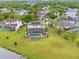 Aerial view of home with a pool, screen enclosure, and backyard that backs up to a lake at 13640 Dornoch Dr, Orlando, FL 32828