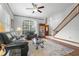 Bright and airy living room featuring a staircase, large windows, and stylish furnishings at 13640 Dornoch Dr, Orlando, FL 32828