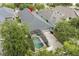 Aerial view of the property showcasing its screened pool area, roof, driveway, and surrounding greenery at 14131 Paradise Tree Dr, Orlando, FL 32828