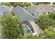 Aerial view of the property showcasing its screened pool area, roof, driveway, and surrounding greenery at 14131 Paradise Tree Dr, Orlando, FL 32828