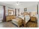 Warm bedroom with wood furnishings, including a bed with decorative pillows and hardwood flooring at 14131 Paradise Tree Dr, Orlando, FL 32828