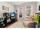 Cozy living room with a comfortable recliner, built-in bookshelves, and bright windows with patterned curtains at 14131 Paradise Tree Dr, Orlando, FL 32828