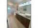 Bathroom with dual sinks, granite countertops, dark wood cabinets and a floral shower curtain at 1474 Thornhill Cir, Oviedo, FL 32765