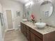 Bathroom with dual sinks, granite countertops, dark wood cabinets and matching round mirrors at 1474 Thornhill Cir, Oviedo, FL 32765