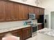 This kitchen features stainless appliances, granite countertops, and dark wood cabinets at 1474 Thornhill Cir, Oviedo, FL 32765