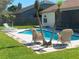 Exterior view of backyard featuring a pool with lounge chairs and palm trees, perfect for relaxation at 1474 Thornhill Cir, Oviedo, FL 32765