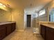 Bathroom with granite countertops, dual sinks, glass shower, and tile flooring at 15157 Pigeon Plum Ln, Winter Garden, FL 34787