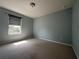A carpeted bedroom finished in neutral paint with horizontal shades over the window at 15157 Pigeon Plum Ln, Winter Garden, FL 34787
