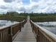 Scenic wooden bridge stretching over the tranquil pond, perfect for a peaceful stroll at 15157 Pigeon Plum Ln, Winter Garden, FL 34787