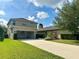 Attractive home exterior with a well-maintained lawn and long concrete driveway at 15157 Pigeon Plum Ln, Winter Garden, FL 34787