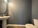 Stylish half-bathroom with pedestal sink, toilet, and modern fixtures at 15157 Pigeon Plum Ln, Winter Garden, FL 34787