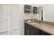 Granite countertop bathroom sink featuring dark cabinets, adjacent to two doors, offering convenience and privacy at 16892 Hypatia Aly, Winter Garden, FL 34787