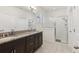 Bathroom with double sinks, dark wood cabinets, and a glass enclosed shower at 16892 Hypatia Aly, Winter Garden, FL 34787