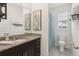 Bathroom featuring granite counters, dark cabinets, and a shower tub combination with modern fixtures at 16892 Hypatia Aly, Winter Garden, FL 34787