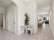 Bright and airy foyer with elegant tile flooring, a decorative plant, and a view into the open-concept living space at 16892 Hypatia Aly, Winter Garden, FL 34787