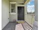 Close-up view of the home's entry, featuring a stylish black door and a welcoming porch with patterned brick at 16892 Hypatia Aly, Winter Garden, FL 34787