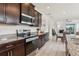 Kitchen with stainless steel appliances and granite countertops, flowing into a dining area with wood cabinetry at 16892 Hypatia Aly, Winter Garden, FL 34787