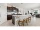 Open kitchen with granite counters, stainless appliances, and large island with barstool seating overlooking the living area at 16892 Hypatia Aly, Winter Garden, FL 34787