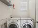 Laundry room featuring a white washer and dryer with a wire rack and a window at 16892 Hypatia Aly, Winter Garden, FL 34787