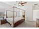 Bedroom with a wooden four poster bed, ceiling fan and adjacent ensuite bathroom at 16892 Hypatia Aly, Winter Garden, FL 34787