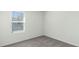 Neutral bedroom featuring gray carpet, baseboards, and a window allowing for natural light at 186 Amberwood Way, Umatilla, FL 32784