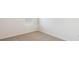 Neutral bedroom featuring beige carpet, baseboards, and a window allowing for natural light at 186 Amberwood Way, Umatilla, FL 32784