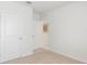 Neutral bedroom featuring beige carpet, baseboards, and a white door at 186 Amberwood Way, Umatilla, FL 32784