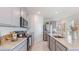 Contemporary kitchen with stainless steel appliances, granite countertops and gray cabinetry at 186 Amberwood Way, Umatilla, FL 32784