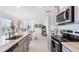 Open-concept kitchen with stainless steel appliances and seamlessly connected living space at 186 Amberwood Way, Umatilla, FL 32784