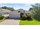 Charming single-story home featuring a well-maintained lawn and a two-car garage with paver driveway at 1925 Estuary Ln, Kissimmee, FL 34747
